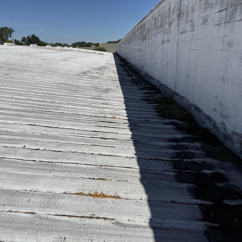 Project photo: Roof-to-Wall Leak Repair on SPF-Coated PBR Metal Roof | 120,000 SF Facility